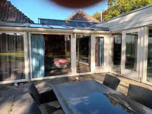 a screened in porch with a table and chairs at Beemster b&b in Zuidoostbeemster