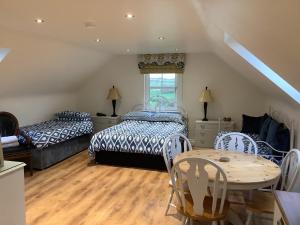1 Schlafzimmer mit 2 Betten, einem Tisch und einem Esszimmer in der Unterkunft Drum Manor Apartment Hillsborough BT26 6PU in Hillsborough