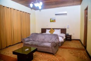 1 dormitorio con 1 cama y 1 sofá en Airside Hotel, en Accra