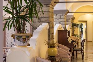 a living room with a plant in a vase at Hotel Nettuno in Ischia