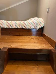 uma cama em cima de um piso de madeira em OpenSpace Vista Panoramica em Abetone