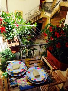 a table with plates of food on a balcony with flowers at Casa Kina Marsala in Marsala
