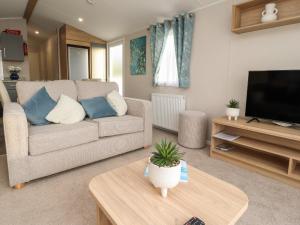 a living room with a couch and a tv at 32 Bayview in Morecambe