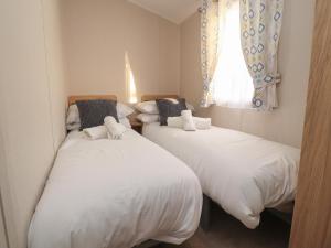two twin beds in a room with a window at 32 Bayview in Morecambe