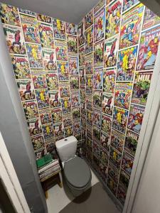 La salle de bains est pourvue d'un mur recouvert de bandes dessinées. dans l'établissement Inspirujące miejsce z widokiem na Miasto!, à Łódź