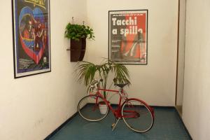 una bicicleta roja estacionada en un pasillo con una planta en Casa Kina Marsala, en Marsala