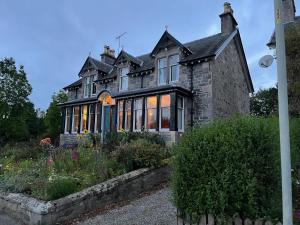 a large house with a garden in front of it at Brooklynn Guest House in Grantown on Spey