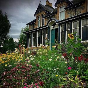 a house with a field of flowers in front of it at Brooklynn Guest House in Grantown on Spey