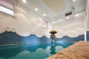 a swimming pool with a vase of flowers in the middle at Hotel Nettuno in Ischia