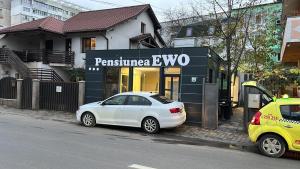 a white car parked in front of a store at Pensiunea Ewo in Iaşi
