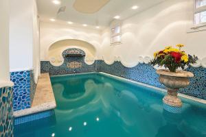 a swimming pool with a vase with flowers in it at Hotel Nettuno in Ischia