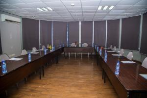 une salle de conférence avec de longues tables et chaises dans l'établissement Airside Hotel, à Accra