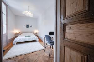 sypialnia z łóżkiem, biurkiem i krzesłem w obiekcie Grand appartement 8 personnes terrasse privative hyper centre calme w mieście Lons-le-Saunier