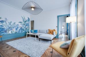 salon z kanapą i stołem w obiekcie Grand appartement 8 personnes terrasse privative hyper centre calme w mieście Lons-le-Saunier