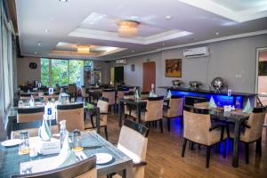 Airside Hotel في آكرا: غرفة طعام مع طاولات وكراسي في مطعم