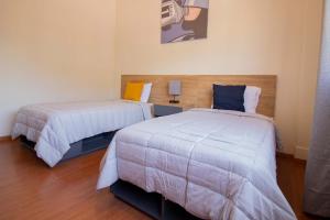 1 dormitorio con 2 camas y lámpara. en Hostal 170 en Orizaba