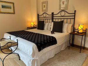 a bedroom with a large bed with black and white sheets at Corzo Hotel in Cercedilla