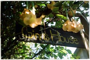 una señal colgando de un árbol con flores en Ginn's House, en Sa Pả
