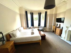 a bedroom with a bed and a room with a tv at Melton Guest House in York