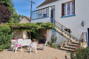 a patio with a bench and chairs in front of a house at Les Noyers Monestois entre Cher et Canal de Berry in Mennetou-sur-Cher