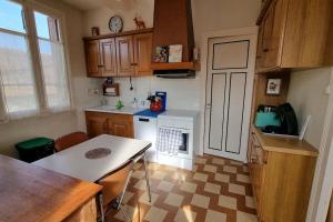 eine Küche mit einem Herd und einem Tisch darin in der Unterkunft Les Noyers Monestois entre Cher et Canal de Berry in Mennetou-sur-Cher + 26 Fotos