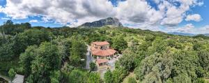 a house on a hill with a mountain in the background at Verdeblu Country Hotel in San Giovanni a Piro
