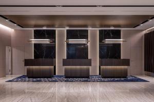 eine Lobby mit schwarzen Marmorwänden und einer Reihe von Stühlen in der Unterkunft Zurich Marriott Hotel in Zürich