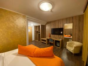 フェルトレにあるHotel Casagrandeのオレンジの枕付きのベッドが備わるホテルルームです。
