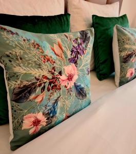 a pillow with a flower pattern on a bed at B&B Apartment Amsterdam Schiphol Airport in Hoofddorp
