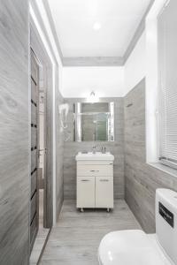 La salle de bains blanche est pourvue d'un lavabo et de toilettes. dans l'établissement White House, à Tbilissi