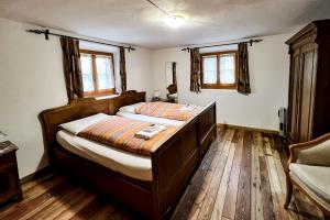 a bedroom with a large bed with wooden floors and windows at Albergo Ristorante Selva in Poschiavo