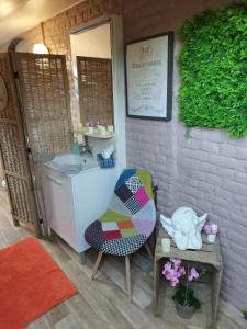 mała łazienka z umywalką i krzesłem w obiekcie Maison d hôtes Les Notes Endormies " Suite La Mystérieuse" w mieście Berzée