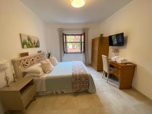 a bedroom with a bed and a desk and a television at Sperlonga Shores in Sperlonga