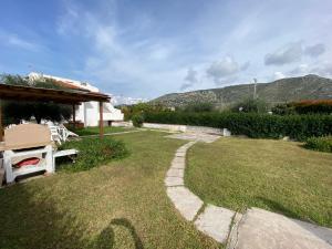 a grassy yard with a pathway leading to a house at Sperlonga Shores in Sperlonga