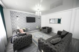 a living room with two couches and a flat screen tv at Pensiunea Lor in Sighetu Marmaţiei