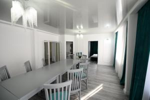 a white room with a long table and chairs at Pensiunea Lor in Sighetu Marmaţiei