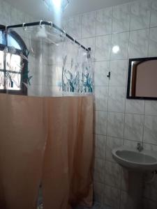 uma casa de banho com uma cortina de chuveiro e um lavatório em Lionfish Hostel em Caraguatatuba