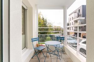 balcón con mesa, sillas y ventana en Les Rives de L'Erdre, en Nantes