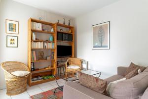 a living room with a couch and a tv at Les Rives de L'Erdre in Nantes
