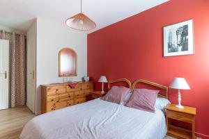 a bedroom with a bed with a red wall at Les Rives de L'Erdre in Nantes