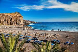 a sandy beach with umbrellas and the ocean at Villa Julia Relax Dream Holiday in Callao Salvaje
