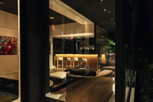 a room with a bar with chairs and a window at M House Hotel in Milano Marittima