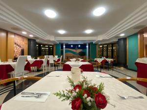 a dining room with tables with roses on them at Hotel Casagrande in Feltre