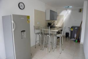 Una cocina con una encimera con taburetes y un refrigerador. en apartamento de 2 habitaciones central en Cali, en Cali 5 fotos más