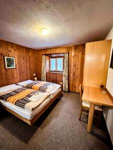 a bedroom with a bed and a wooden wall at Albergo Ristorante Selva in Poschiavo