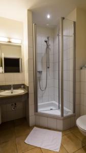 ein Bad mit einer Dusche und einem Waschbecken in der Unterkunft Hotel Kieler Förde in Kiel