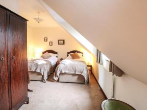 two beds in a room with a staircase at Walnut Tree Cottage in Great Yarmouth