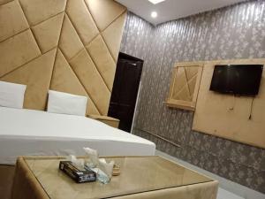 una camera con letto e TV a parete di Hotel Sereena residence a Multan