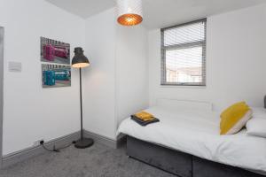 a bedroom with a bed and a lamp and a window at No 1 School House in Leyland