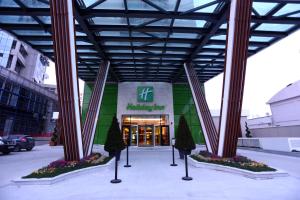 un edificio con colonne e alberi di fronte ad esso di Holiday Inn Ankara - Cukurambar, an IHG Hotel a Ankara